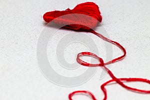 Red heart shape symbol made from wool on white