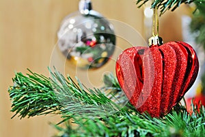 Red heart shaped Christmas decoration on Christmas tree