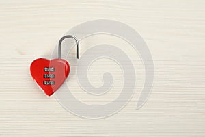 Red heart shaped combination lock on white wooden table, top view. Space for text
