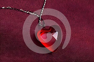 Red heart-shaped pendant on leather fabric