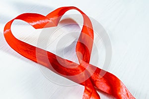Red heart shaped ribbon awareness on white background. World aids day concept