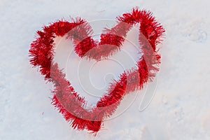 A red heart in the snow made of christmas wires