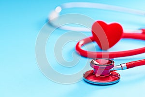 Red heart and stethoscope on on blue background.Selective focus.