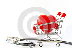 Red heart in a supermarket trolley and stethoscope. The concept of medicine and health insurance.