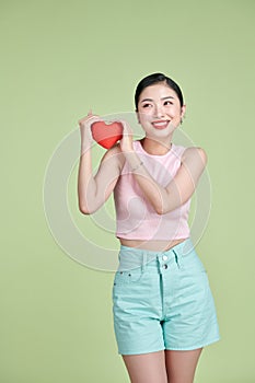 Red heart symbol of Valentines day smiling woman hold