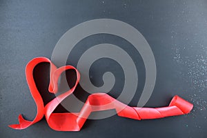 Red heart of tape with curls on black gray background with copyspace place for text valentine`s day