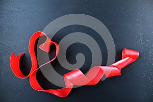 Red heart of tape with curls on black gray background with copyspace place for text valentine`s day
