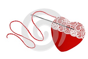 Red heart, thread and needle isolated on white