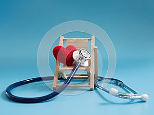 Red heart using deep blue stethoscope on the blue background. Concept of love and caring patient by the heart or get sick on trave