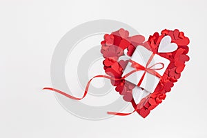 Red heart for Valentine or Mother day from various mixed paper hearts with gift or present box on white background top view