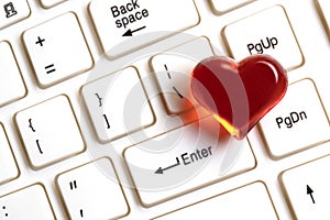 Red heart on a white computer keyboard. The concept of gifts for Valentine`s Day, love correspondence and meeting on social