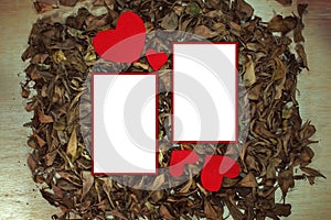 Red heart and white paper on dread leaves