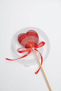 Red heart with white and red ribbon. Symbol of love, handmade on a white background. Decorative element for Valentine\'s Day