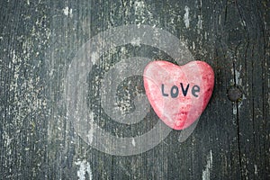 Red heart and wooden background in country style.