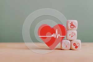 Red heart and wooden block with medical and health icon for wellbeing and health insurance concept