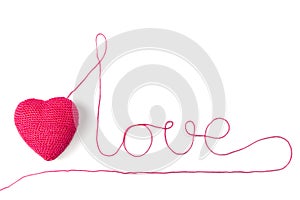 Red heart and yarn in the shape of a word Love. Isolated on white background