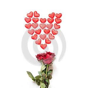 Red hearts as shape and bouquet of red roses on white. Top view. Valentine`s card concept.