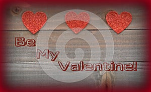 Red hearts with Be My Valentine on wood background