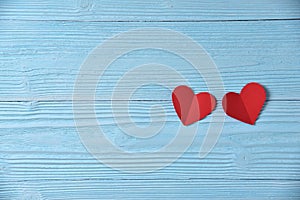 Red hearts on blue wooden background.