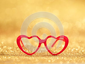 red hearts glasses on gold bokeh background