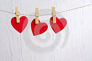 Red hearts hanging on wooden background