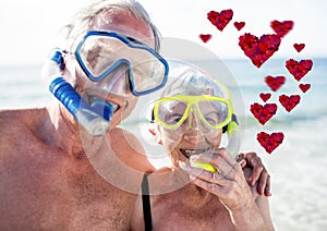 Red hearts and happy senior couple scuba diving