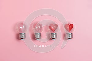 Red hearts in light bulbs. Loading progress bar on pink background