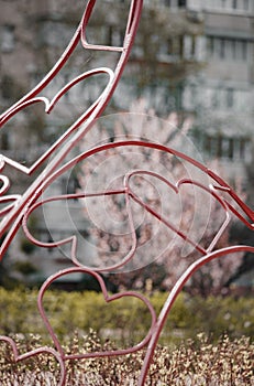 Red hearts made of metal on the background of a residential building