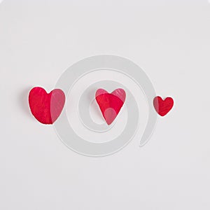 Red hearts made of red rose petals on a white background. Minimal love concept. Mother`s day or Valentines idea