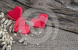 Red hearts on natural wooden and burlap background. Valentines day greeting card. Eco friendly concept