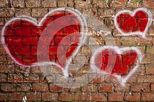 Red hearts painted on a brick wall photo