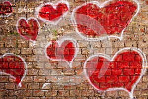 Red hearts painted on a brick wall