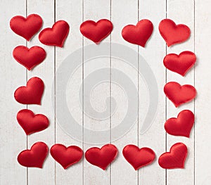 Red Hearts of satin fabric as framework for a words message.  It`s blank in the center and has white shiplap boards background