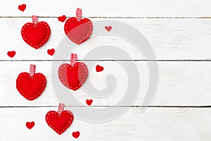 Red hearts sewn from felt on a white wooden background. Copy spa