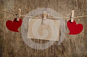 Red hearts with sheet of paper hanging on the clothesline