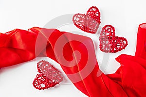 Red hearts and silk ribbon on a white background