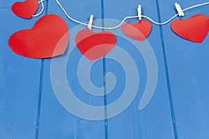 Red hearts on a string on a blue background