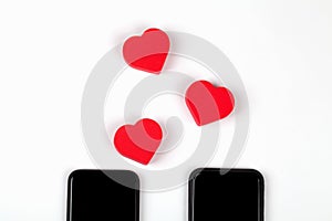 Red hearts and two mobile phones on white background. Internet dating, copy space