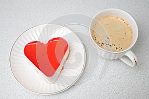Red heart shaped cake for St. Valentines Day celebration with cup of coffee