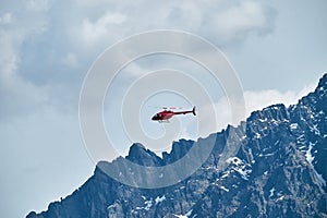 Red helicopter in the sky over the Caucasus Mountains, a beautiful mountain landscape