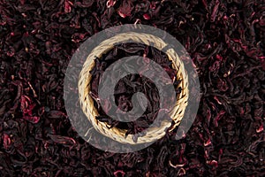 Red hibiscus tea in glass cup on white wooden table with dry rose petals. Hibiscus tea background