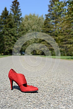 Red high heel shoe on road