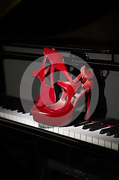 Red high heel shoes on piano