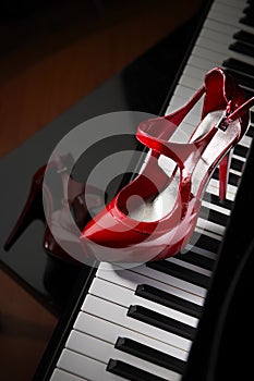 Red high heel shoes on piano