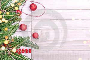 Red holiday bells with Christmas tree on rustic wooden background with festive bokeh lights