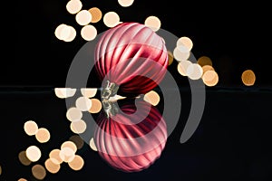 Red holiday ornament refected on glass surface, soft Christmas l