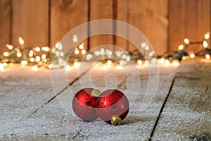 Red holiday ornaments with lights in background