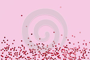 Red holographic star glitter confetti background on pink