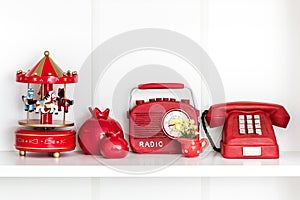 Red Home Related Decorative Objects in a White Shelf