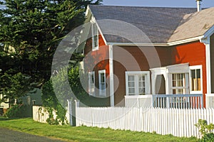 Red home with white picket fence